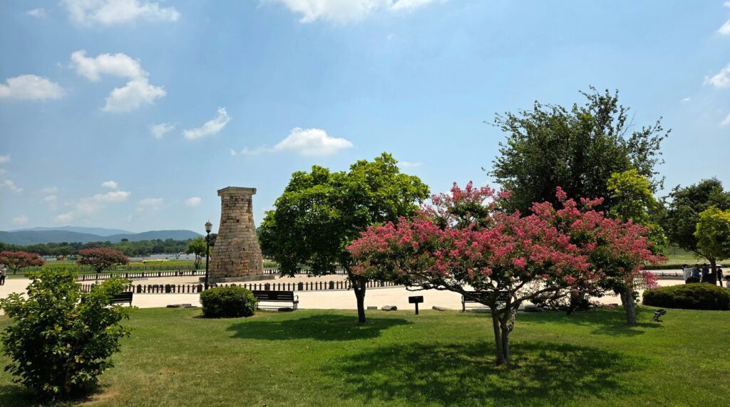 Gyeongju Travel Guide: Korea's Ancient Capital, Temples & Where to Stay (2026) Cheomseongdae, the 7th-century stone observatory in Gyeongju, framed by green parkland and summer blossoms