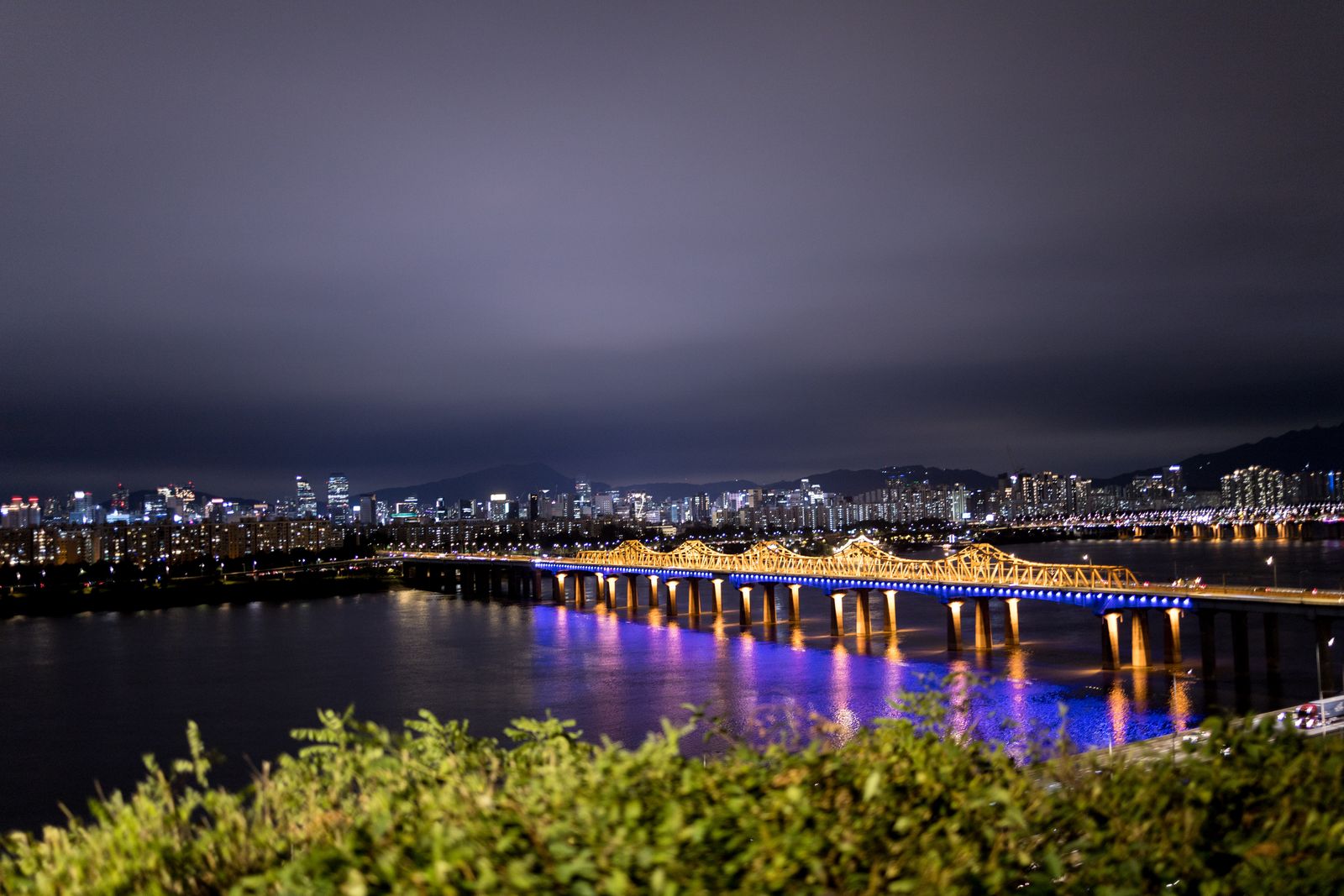 An illuminated bridge over the Han River in Seoul at night