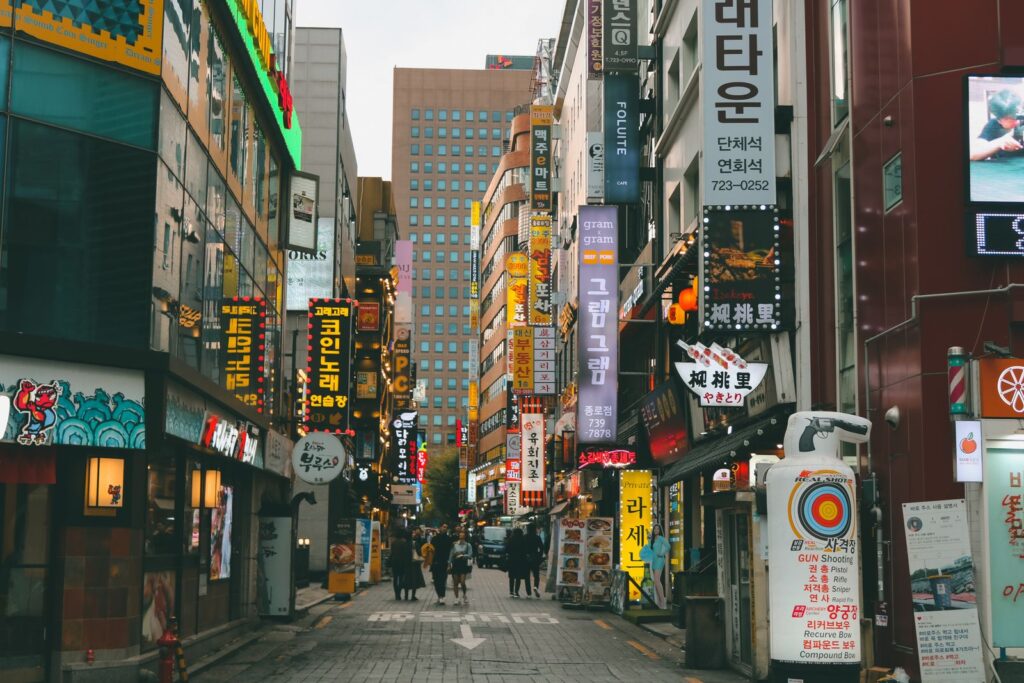 Hongdae, Seoul: Things to Do, Nightlife & Where to Stay (2026) A lively street lined with shops and signs in Hongdae, Seoul