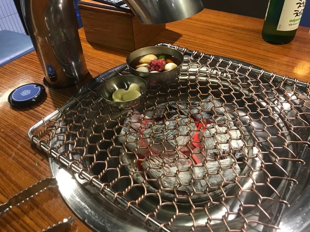 A Korean barbecue grill table set for a shared meal, where dining etiquette centers on the group