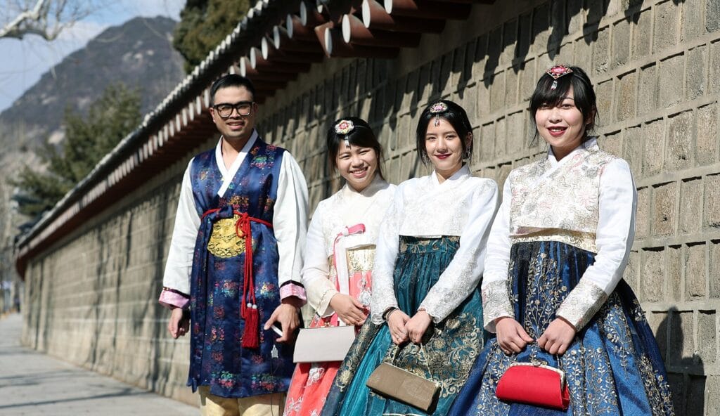 Visitors in rented hanbok at Gyeongbokgung Palace, Seoul, where modest dress and quiet manners are expected
