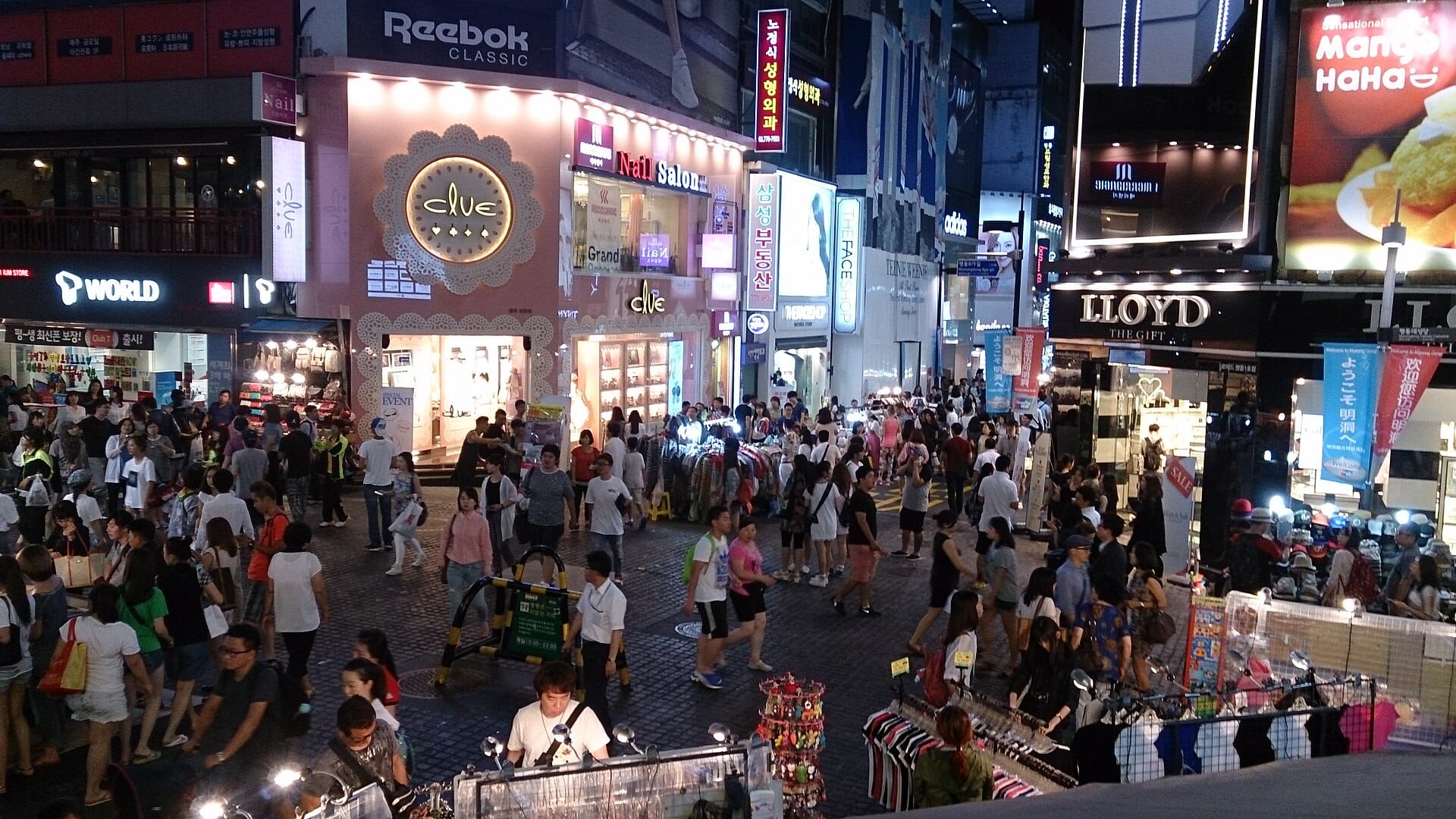 A dense crowd of shoppers filling the Myeongdong shopping street in Seoul