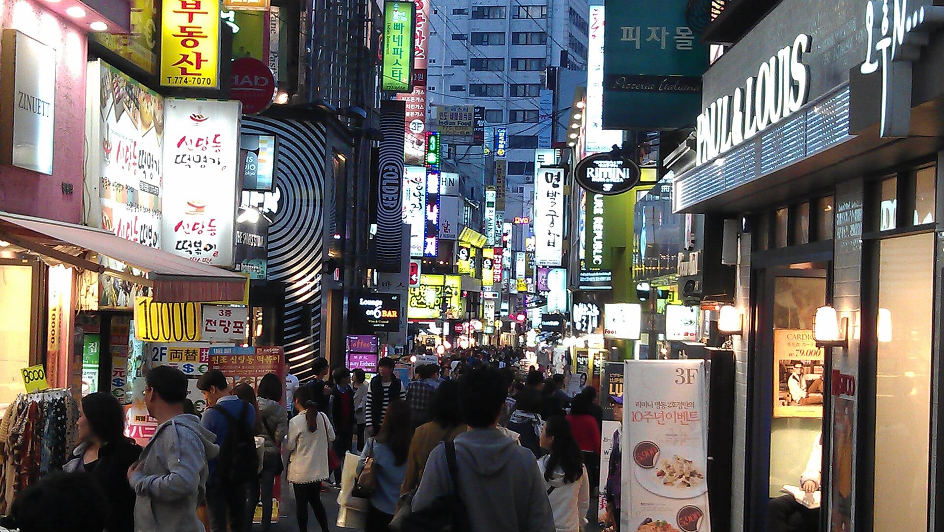 Myeongdong's street-food stalls and neon signs lit up after dark in Seoul