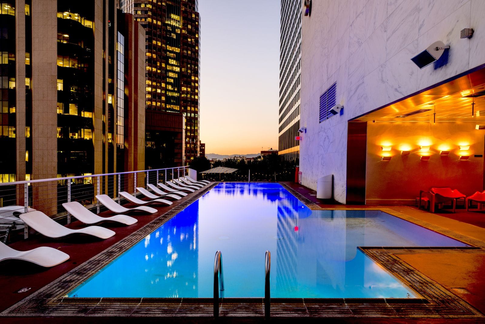 A rooftop hotel pool at dusk overlooking a city skyline, reflecting Seoul's growing 2026 hotel supply