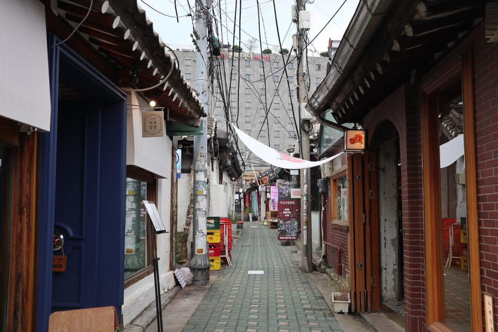 A narrow alley of restored hanok cafés and shops in Ikseondong Hanok Village, Seoul