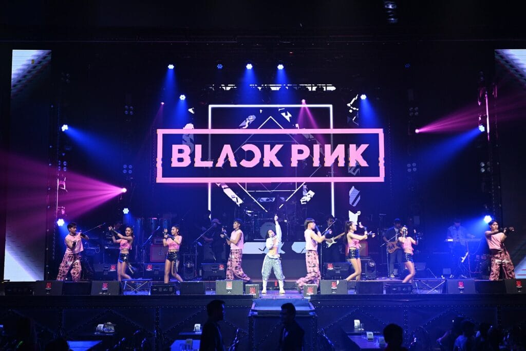 K-World Dream Awards 2026: 10th Anniversary Lineup at KINTEX A large K-pop concert stage lit in pink and blue with performers on stage, similar to the setup expected at a major Korean awards show