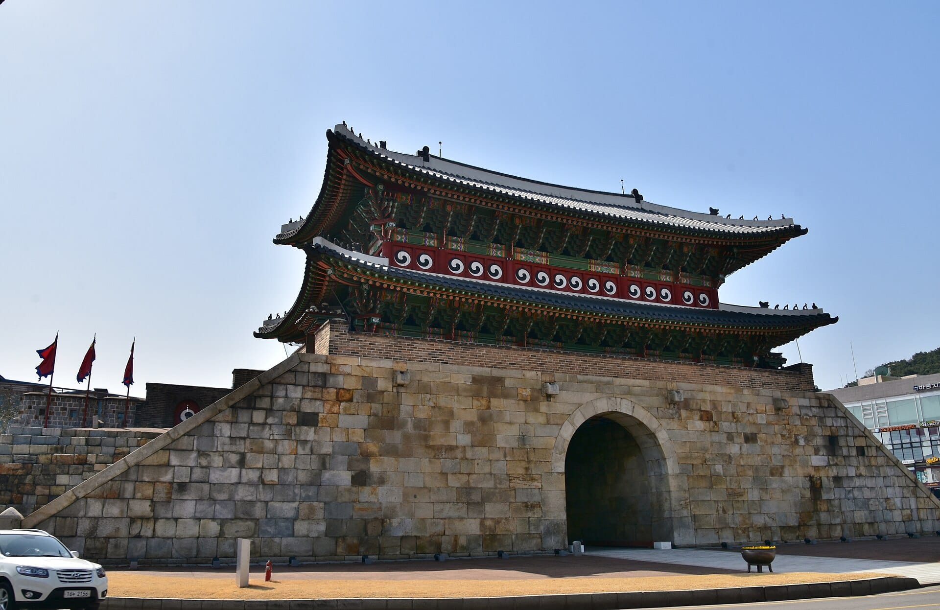 Suwon Hwaseong Fortress Day Trip from Seoul: Complete 2026 Guide A watchtower and section of the Hwaseong Fortress wall in Suwon under clear skies