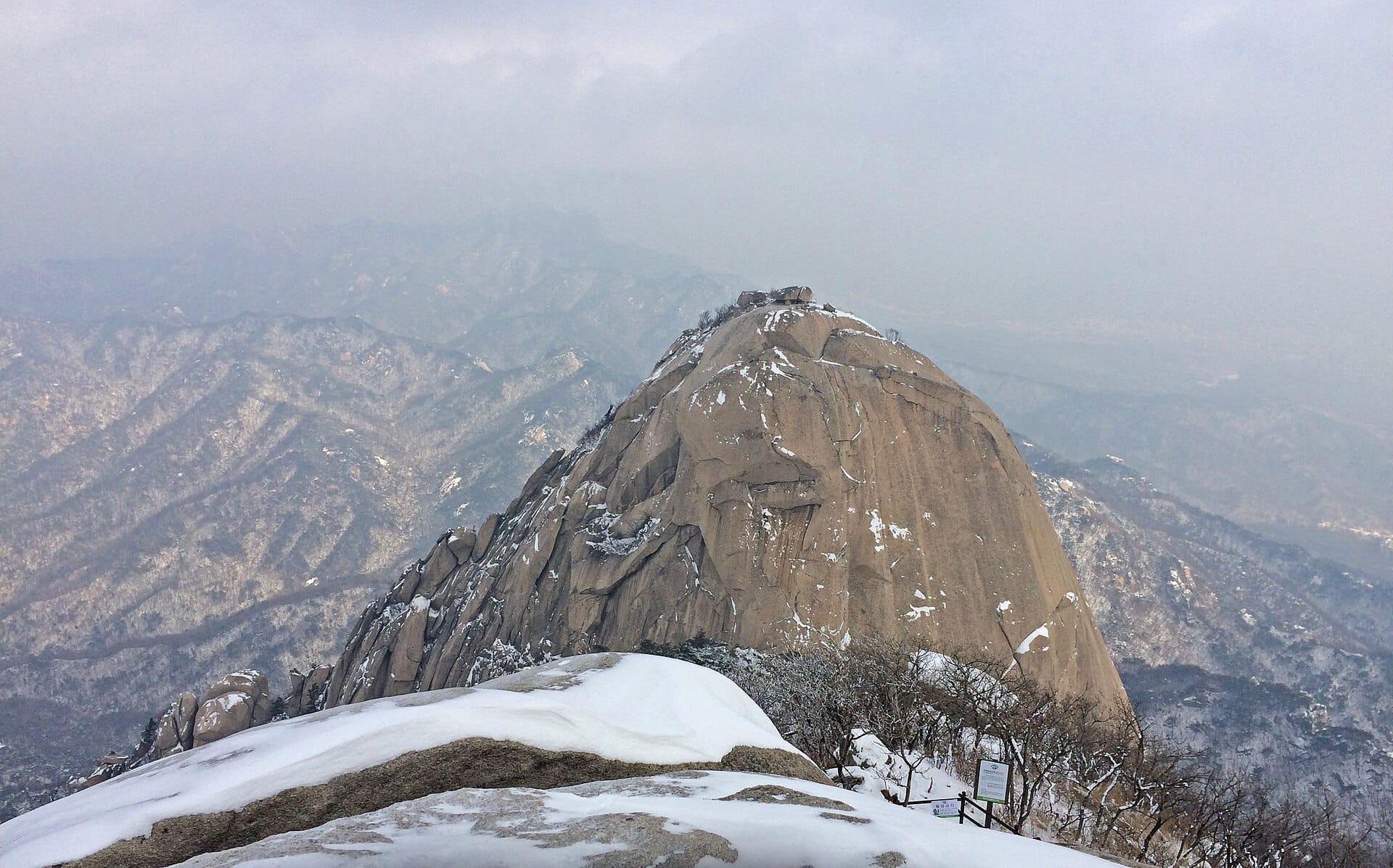 Hikers on the steep granite face and cable-assisted final steps to Baegundae Peak, the highest point in Bukhansan National Park