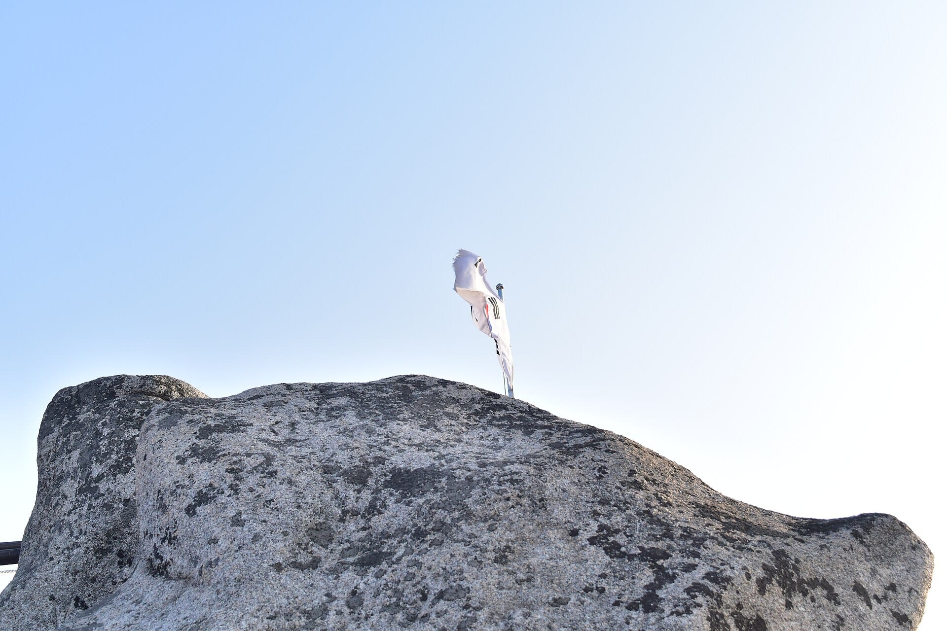 Hikers reaching the summit marker at the top of the Baegundae Peak trail in Bukhansan National Park