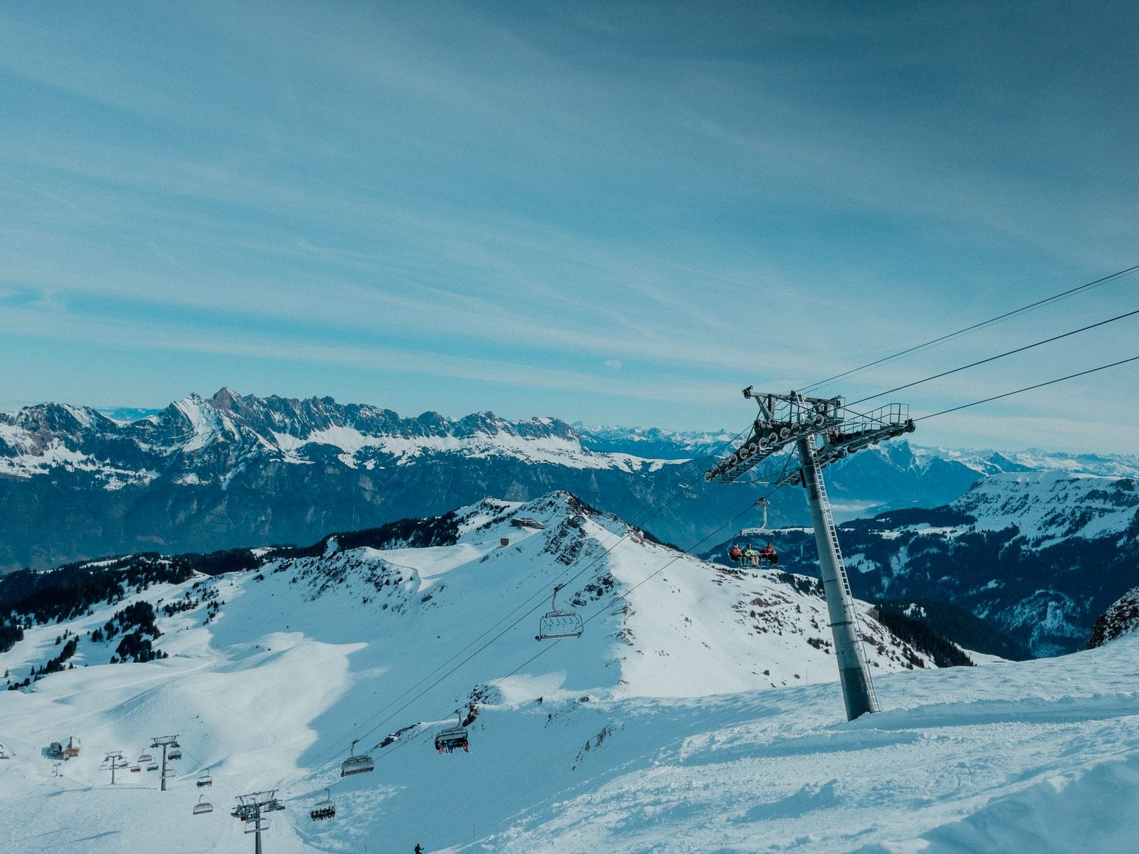 A wide snow-covered ski resort valley with a ski lift running up the mountainside