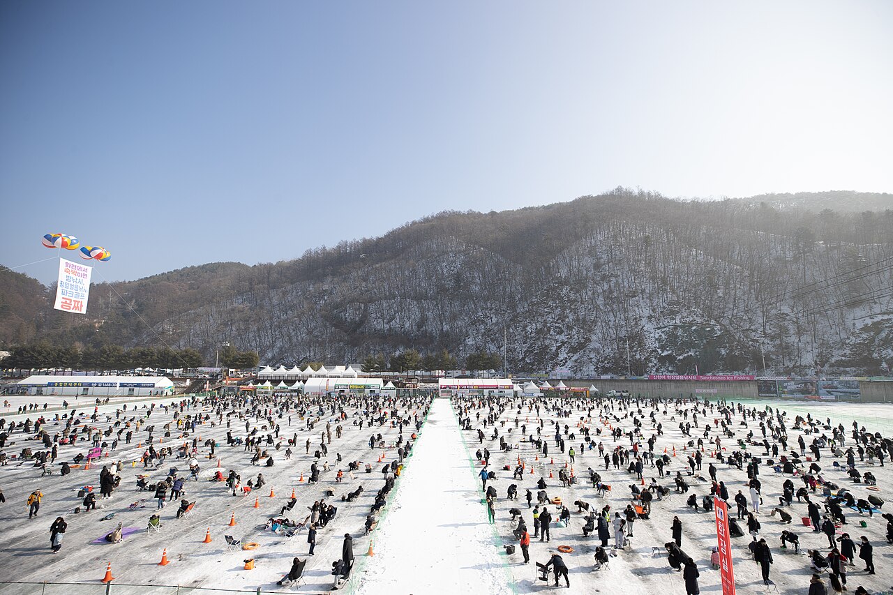 Crowds ice fishing through holes drilled in the frozen Hwacheon Stream at the Hwacheon Sancheoneo Ice Festival in Korea