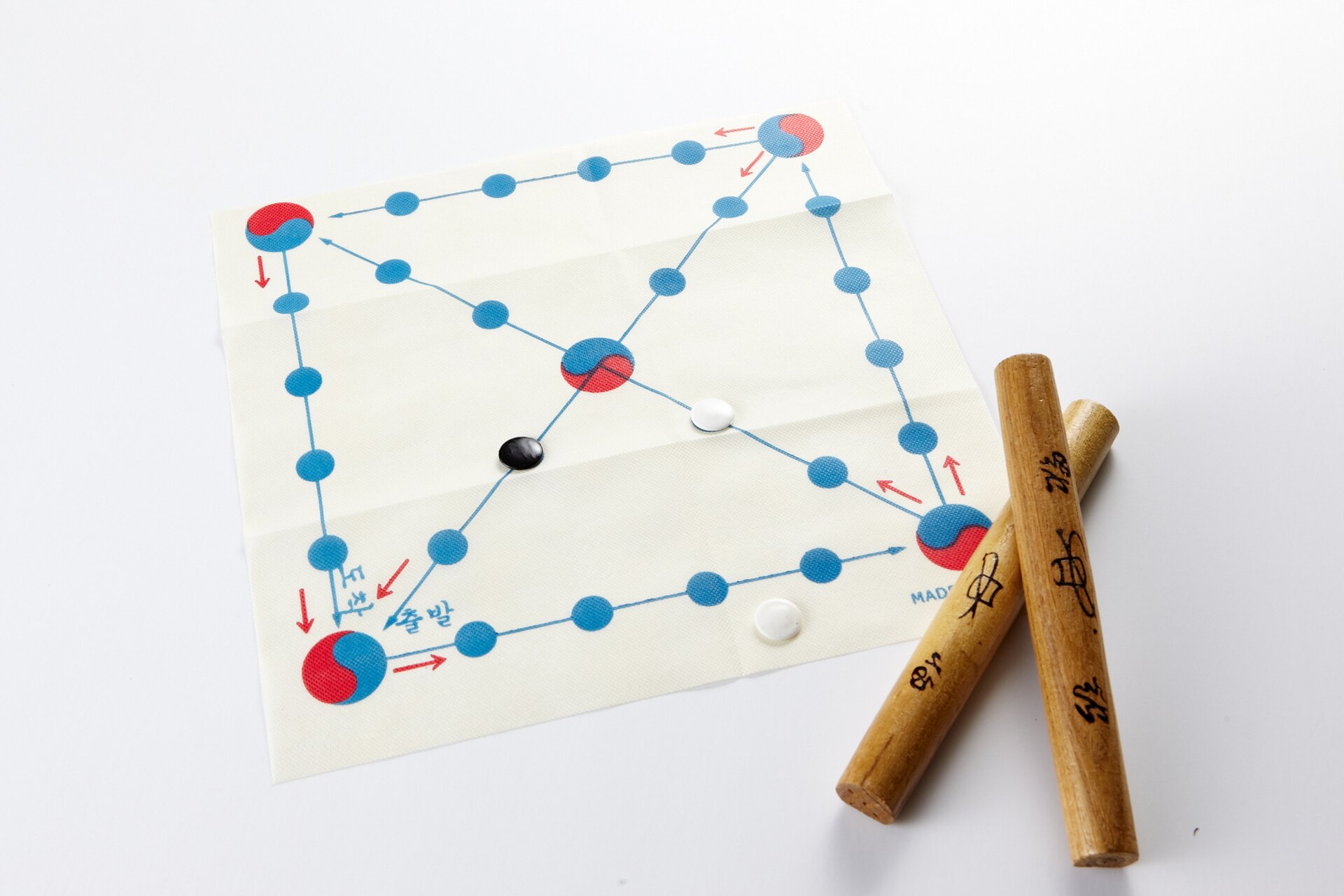 Players throwing wooden yut sticks in yunnori, the traditional board game played at Seollal